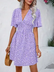 Detailed view of a purple floral V-neck summer dress featuring a pleated high-waist silhouette