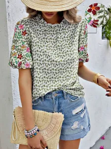 Gros plan détaillé d'une blouse d'été brodée de fleurs avec un col montant à volants chic