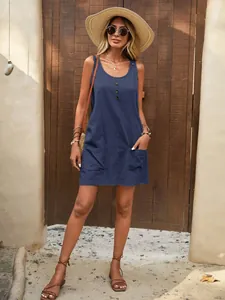 Casual blue sleeveless cotton summer dress with U-neck and front pockets in outdoor setting