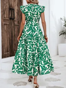Vista trasera de un vestido con estampado de hojas verdes, volantes y falda larga.