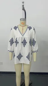 Details einer weißen V-Ausschnitt Bluse mit blauer geometrischer Stickerei, Sommer