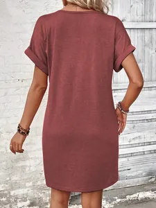 Rear view of a stylish rust-red short sleeve t-shirt dress with rolled cuffs in a casual setting