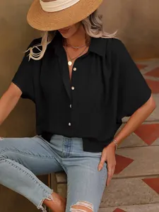 Détail d'une chemise noire à manches courtes pour femme en tissu texturé avec boutonnage