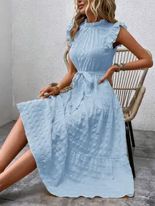 Detail of light blue summer dress featuring ruffle sleeves, mock neck, and textured fabric.