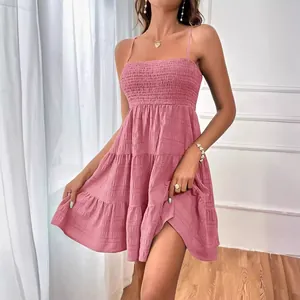 Élégante robe d'été rose à fines bretelles, bustier froncé et tissu texturé multicouche.