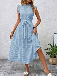 Detail view of light blue tiered dress featuring flutter sleeves and textured fabric