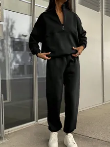 Close-up detail showing the texture and fit of the black half-zip two-piece tracksuit set