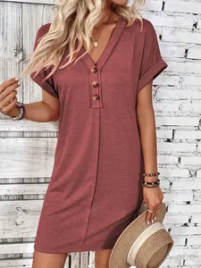Detail view of a dusty rose V-neck dress featuring buttons and rolled short sleeves.