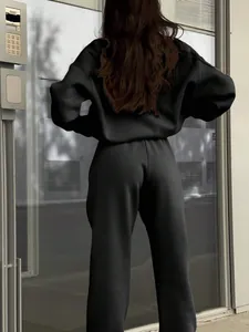 Back view of a woman wearing a stylish black casual two-piece tracksuit set for autumn