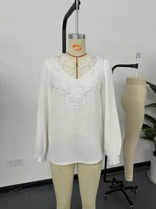 Detailed view of a white V-neck lace blouse with swiss dots on a mannequin