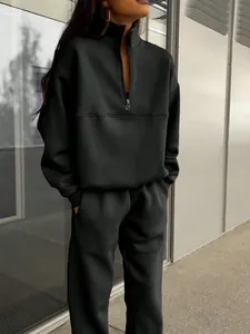 Detail of a chic black two-piece tracksuit set with a half-zip pullover and joggers