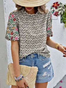 Détail de broderie florale sur un chemisier d'été imprimé à col montant ondulé chic