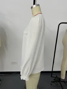 Side view detail of a white textured long sleeve blouse with elegant lace trim decoration