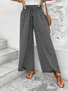 Detailed view of women's high-waisted black and white floral wide-leg pants on stairs