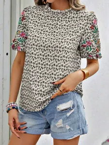 Détail d'une blouse à imprimé fleuri brodé avec col montant et manches bouffantes