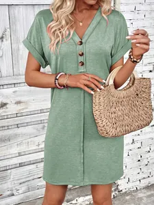 Detail of women's sage green V-neck dress with wood-tone buttons and rolled sleeves.