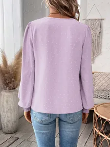 Back view of a purple long-sleeve blouse with swiss dot texture in a cozy room