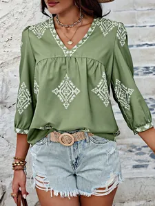 Detailansicht eines grünen Boho-Oberteils mit V-Ausschnitt und geometrischem Print