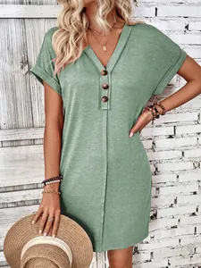Detail shot showing the V-neck and wooden button design on this green mini dress.