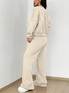 Vue de dos d'une femme portant un ensemble de survêtement beige à deux pièces et capuche