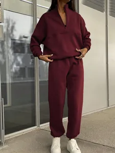 Detail of burgundy two-piece fleece tracksuit with half-zip pullover and joggers