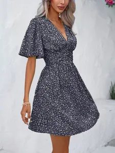 Chic floral V-neck mini dress featuring flutter sleeves and high waisted pleated skirt detail