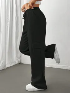 Side view of black wide-leg cargo sweatpants with flap pockets and drawstring waist.