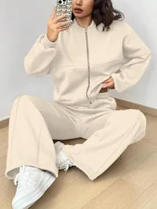 Détail d'un ensemble deux pièces blanc cassé pour femme avec haut zippé et pantalon large.