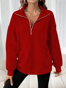 Vue détaillée du sweat-shirt rouge à quart de zip montrant le col et la coupe ample sur un mannequin
