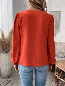 Back view of rust orange Swiss dot long sleeve blouse showing textured fabric details