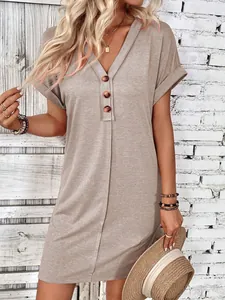 Close-up detail of khaki V-neck summer dress with wood buttons and rolled sleeves fabric.