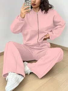 Detailansicht eines rosa zweiteiligen Trainingsanzugs mit Kapuzenjacke und weiter Hose.