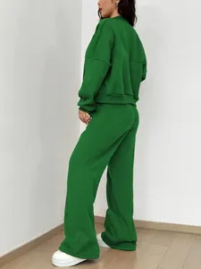 Rückansicht eines leuchtend grünen zweiteiligen Sweatshirt- und Weithosen-Sets für Damen