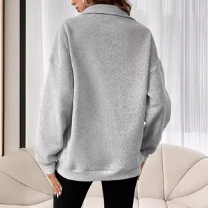 Vue de dos d'un sweat-shirt gris oversize pour femme avec un col à fermeture éclair