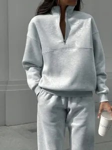 Detail of light grey half-zip sweatshirt and matching sweatpants lounge set.