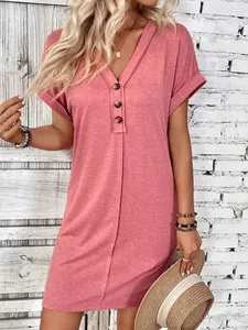 Detailed view of casual pink V-neck t-shirt dress featuring wooden buttons and rolled sleeves
