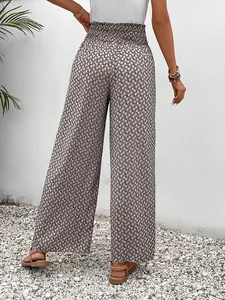 Back view of stylish women's geometric print wide-leg pants featuring a smocked high waist