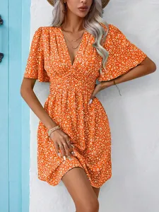 Elegant close-up view of orange floral print V-neck dress with high waist summer design