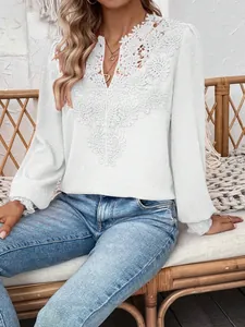 Detailed view of the intricate lace V-neck on a white Swiss dot long-sleeved blouse