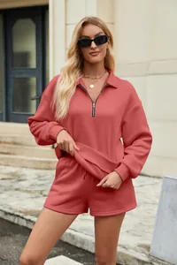 Details eines korallenroten Sets aus Halbreißverschluss-Sweatshirt und Shorts am Model