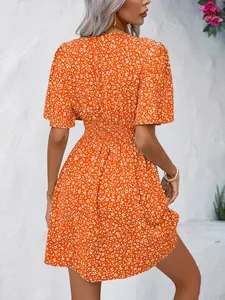Back view of a vibrant orange floral high-waist summer dress with short sleeves on model.