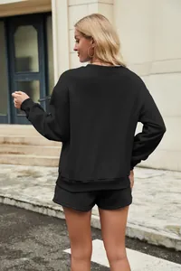 Back view of black two-piece sweatshirt and shorts lounge set on model outdoors