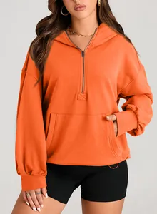 Front detail of orange women's half-zip hoodie with hood and kangaroo pocket