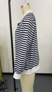 Vue latérale d'un sweat à rayures noires et blanches avec fermeture éclair sur mannequin.