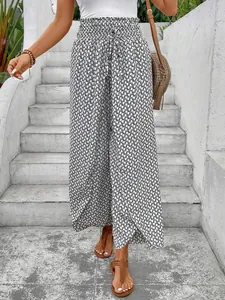 Lower body view of high-waisted wide-leg pants with geometric pattern and side slit