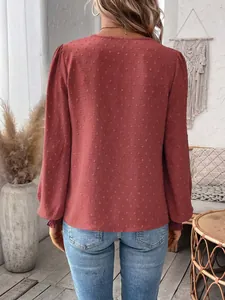 Back view of women's brick red long-sleeve blouse with textured Swiss dot fabric