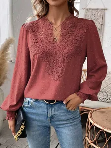 Detail view of women's burgundy V-neck blouse with lace embroidery and Swiss dots