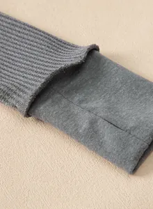 Detalle de primer plano de sudadera gris de punto gofrado con puño de jersey suave