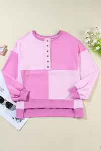 Detailed flat lay of a pink color-block buttoned sweatshirt with ribbed texture
