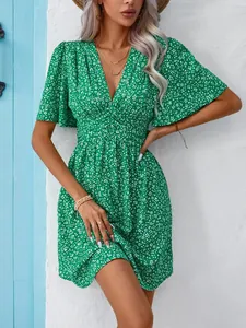 Detailed view of green V-neck floral dress featuring high waist and flutter sleeves